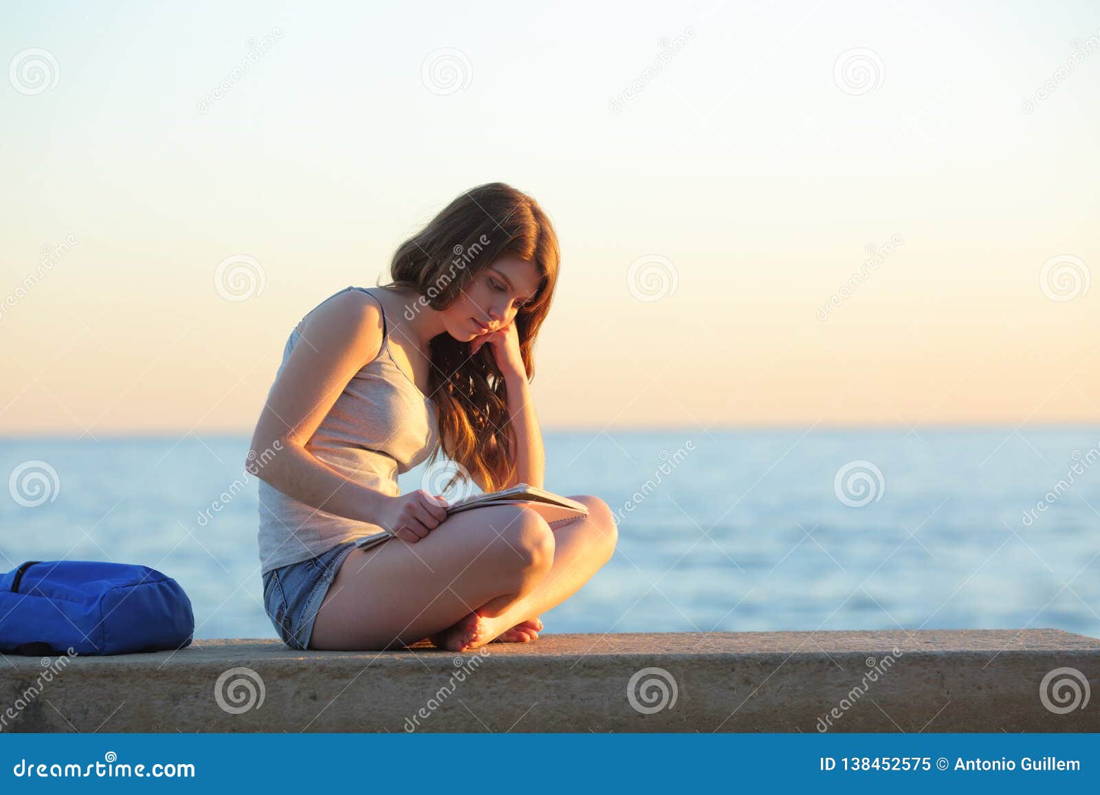 student learning memorizing notes on the beach