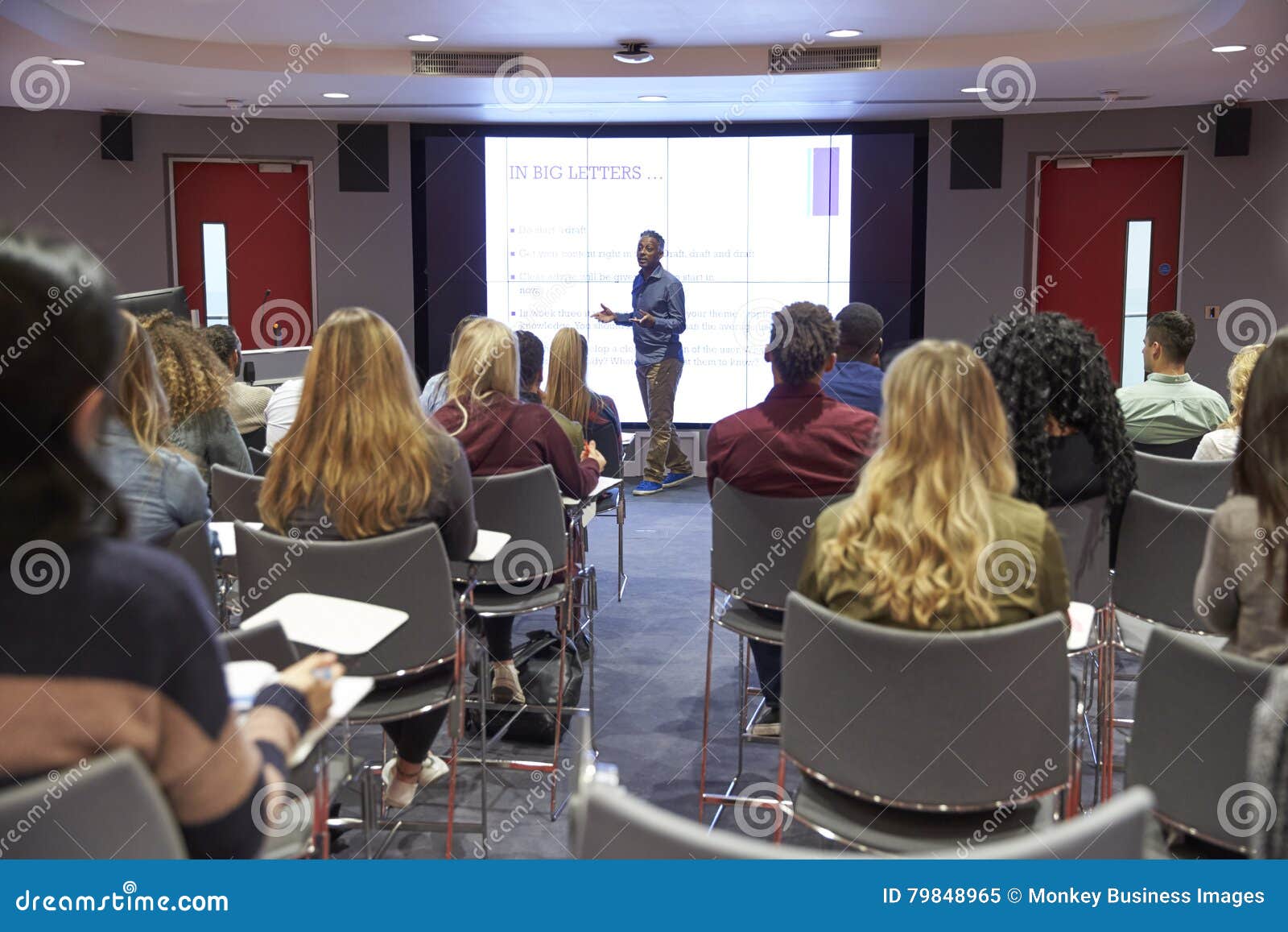 student lecture in modern university classroom, back view