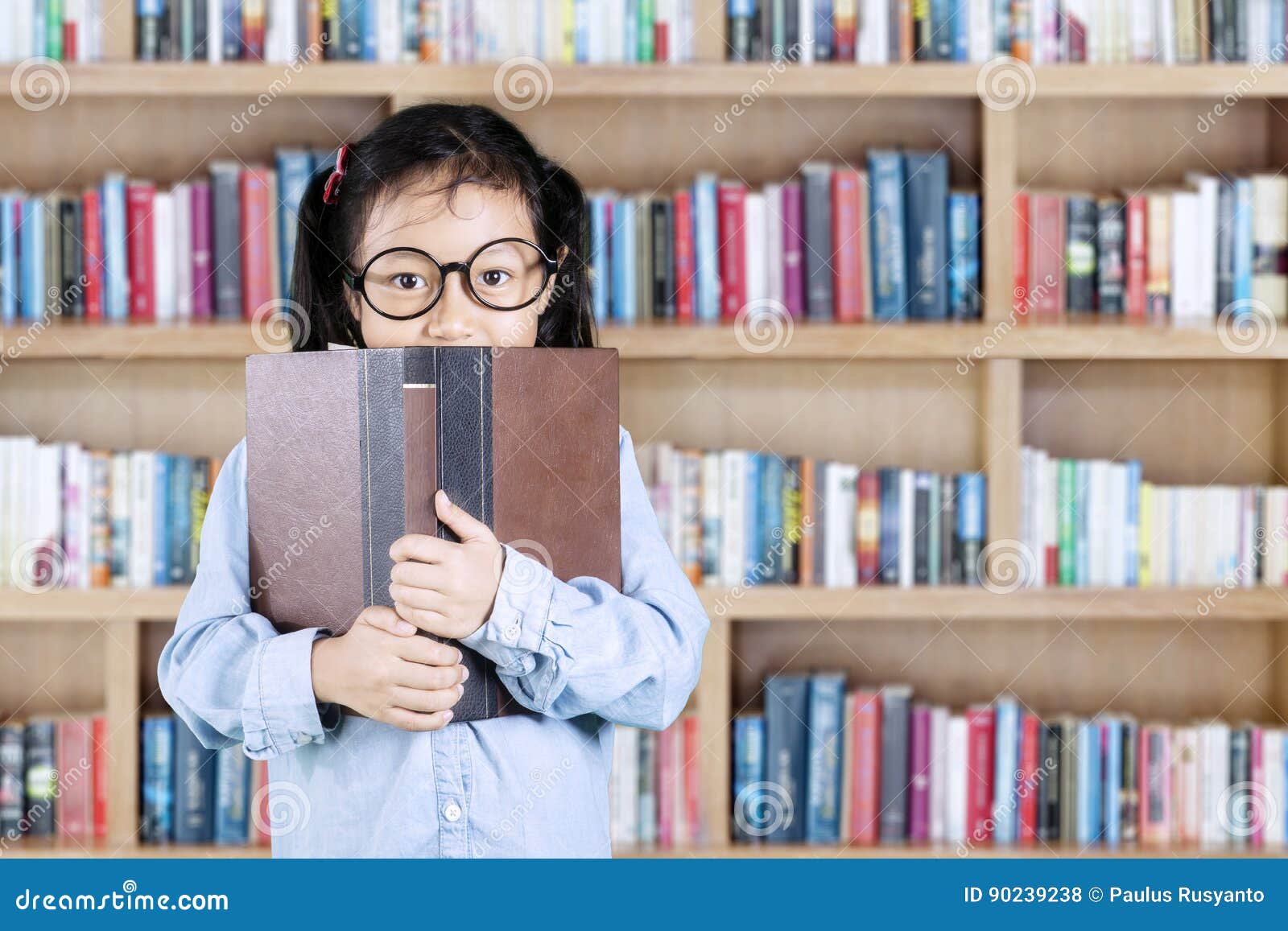 Student Peeking Behind Book in Library Stock Photo - Image of library ...