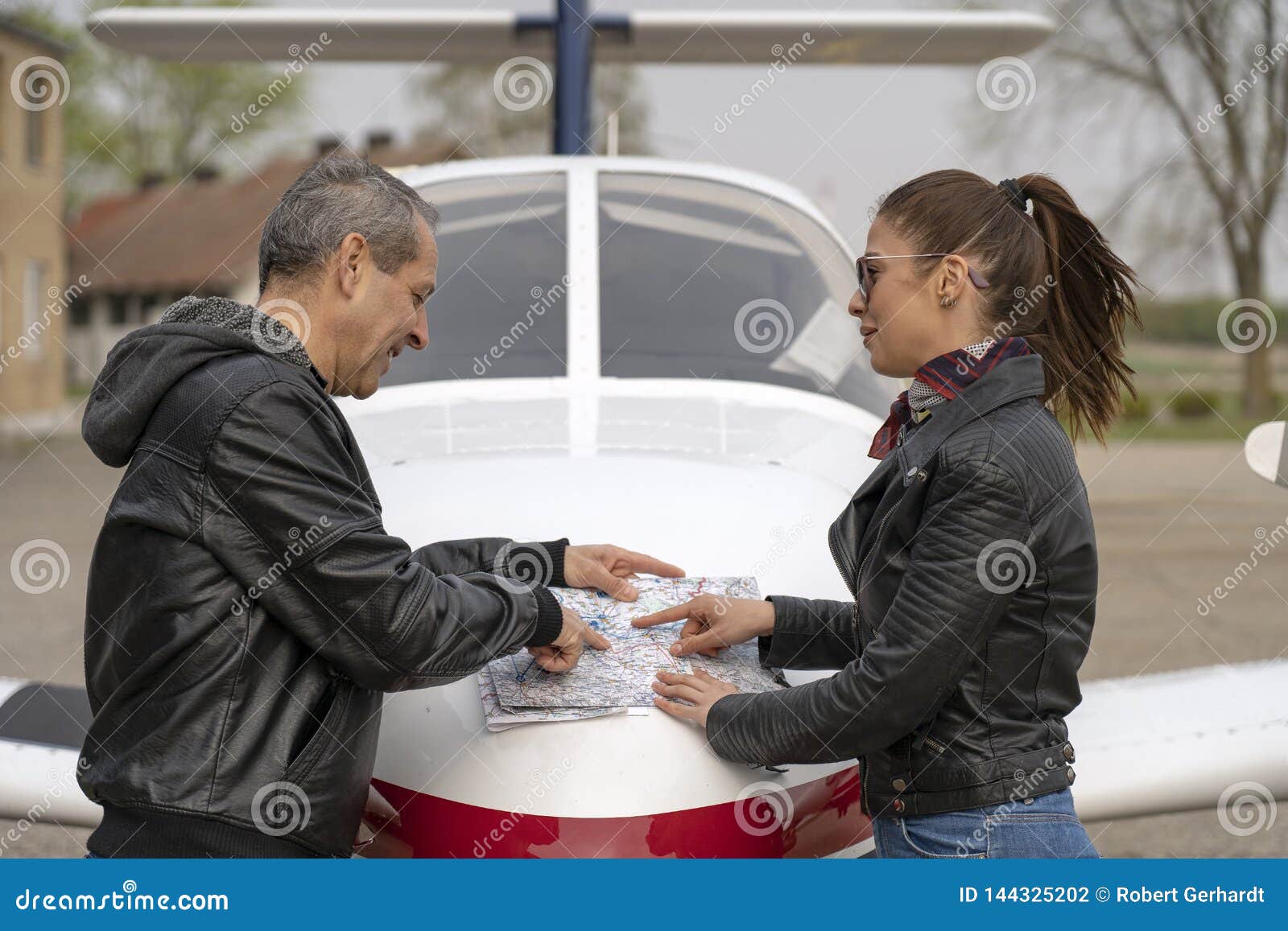 Student And Pilot Discussing Flight Route Over An Aviation Chart Stock Student And Pilot Discussing Flight Route Over An Aviation Chart Stock