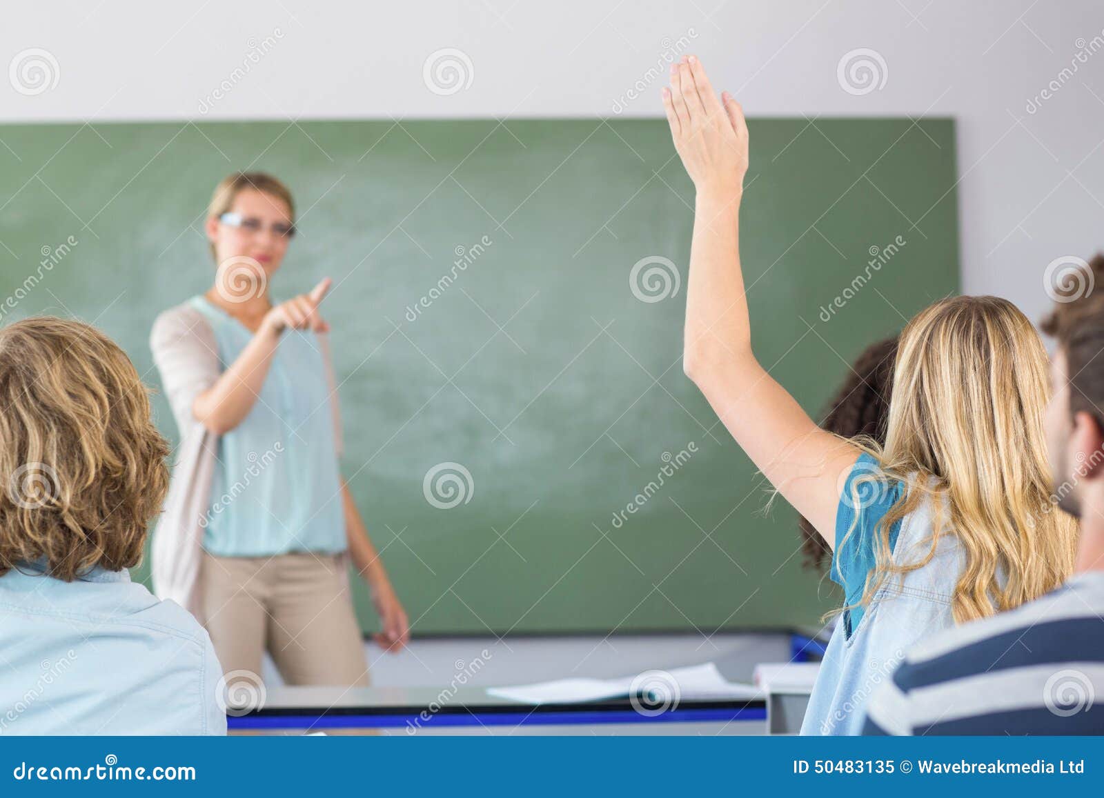student raising hand in classroom