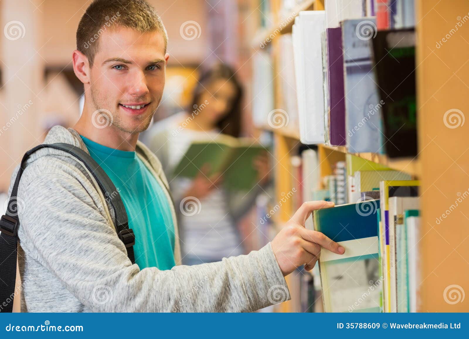 Student Selecting a Book from Bookshelf in the Library Stock Image