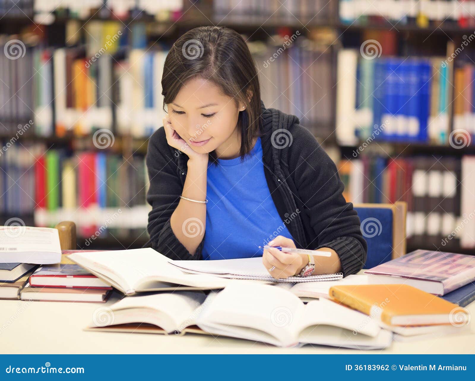 student sitting and reading book in library