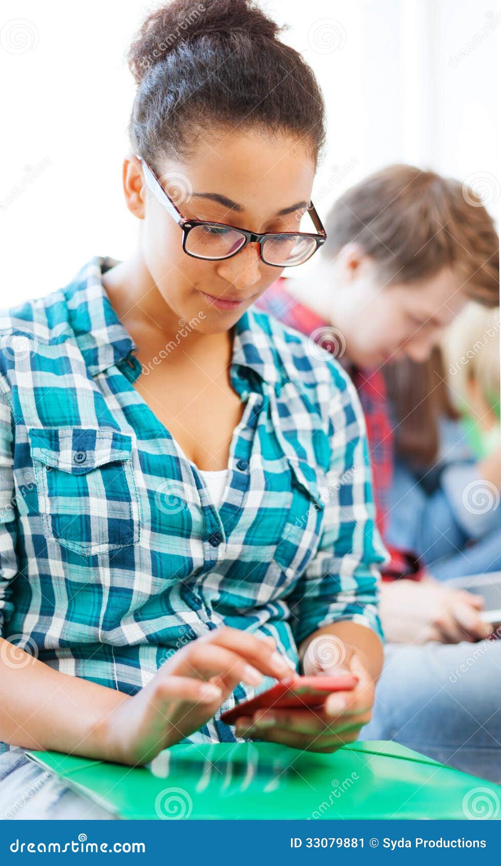 Bildungskonzept - lächelndes internationales Studentenmädchen mit Smartphone in der Schule