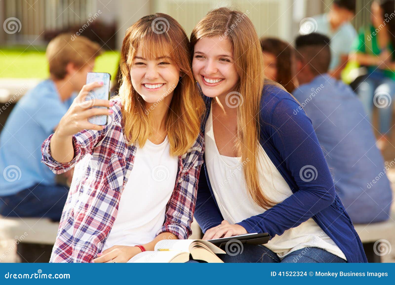 Studenti femminili della High School che prendono Selfie sulla città universitaria. Due studenti femminili felici della High School che prendono Selfie sul sorridere della città universitaria