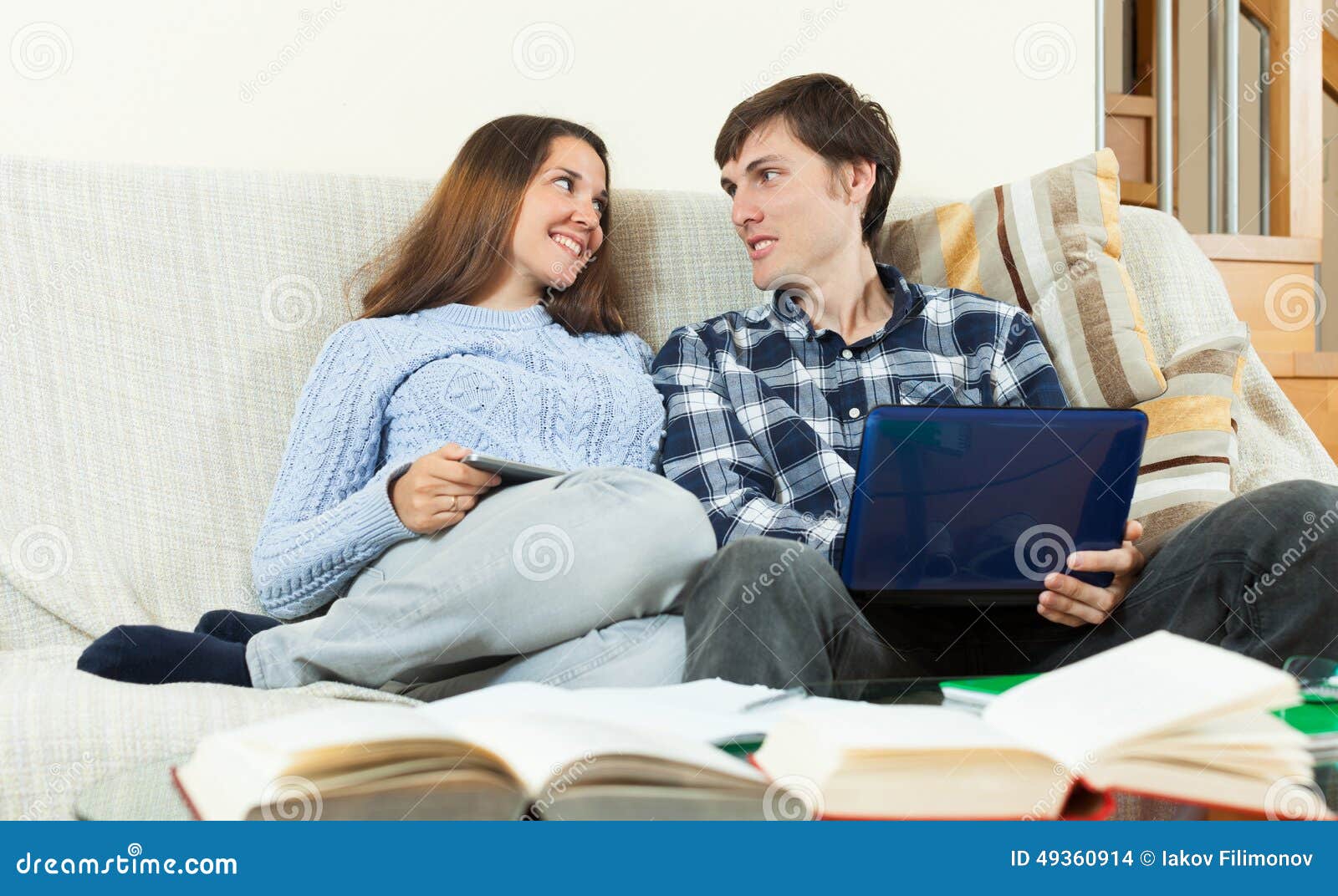 Happy students preparing for exams and studying books at home