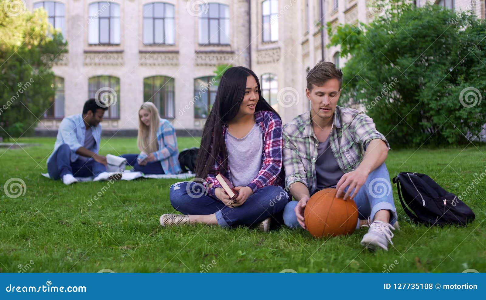 students sitting on grass near college, acquaintance, first day on campus