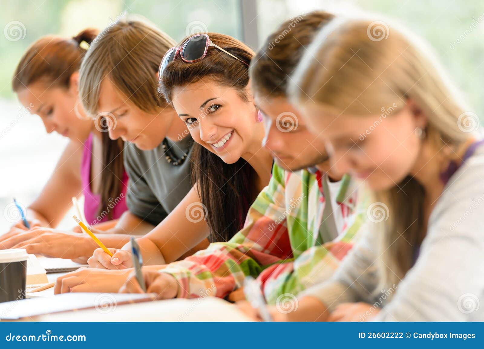 students writing at high-school exam teens study