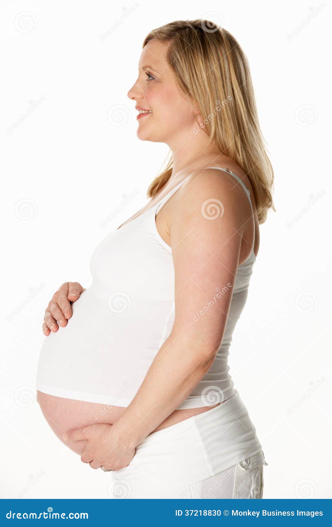 Studio Portrait of 8 Months Pregnant Woman Wearing White Stock Photo