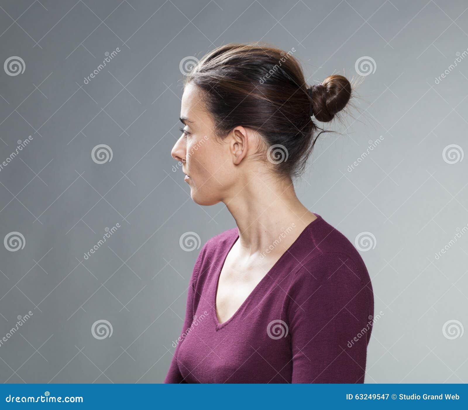 studio portrait of a thinking 30s woman, profile view