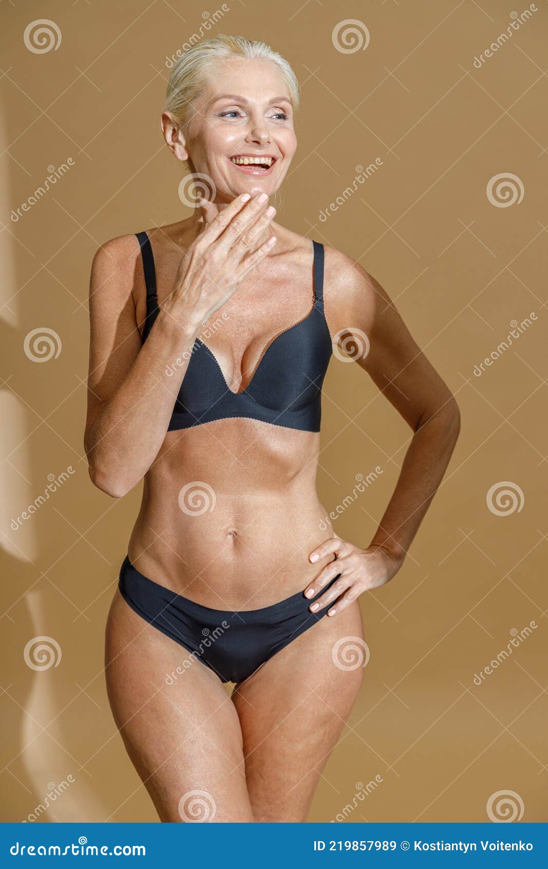 Studio Shot of Happy Mature Woman with Fit Body in Black Underwear Touching  Her Chin and Smiling Aside while Standing Stock Image - Image of face,  blonde: 219857989