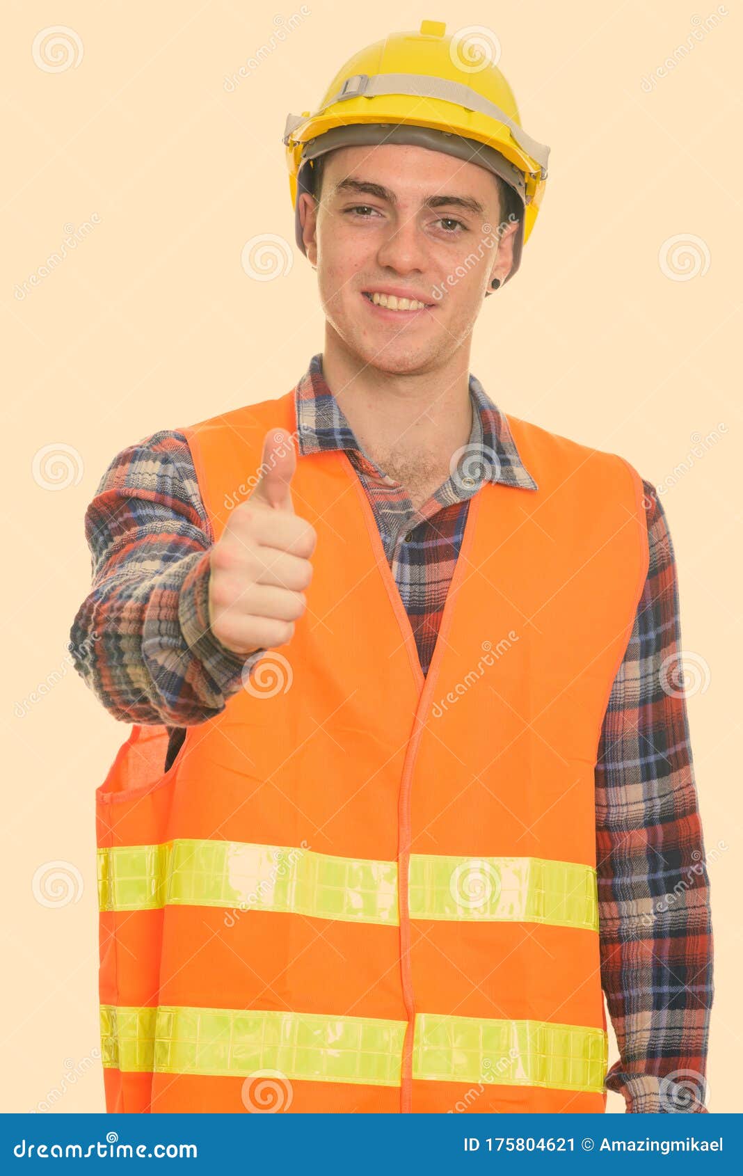 Studio Shot Of Happy Young Man Construction Worker Smiling While Giving