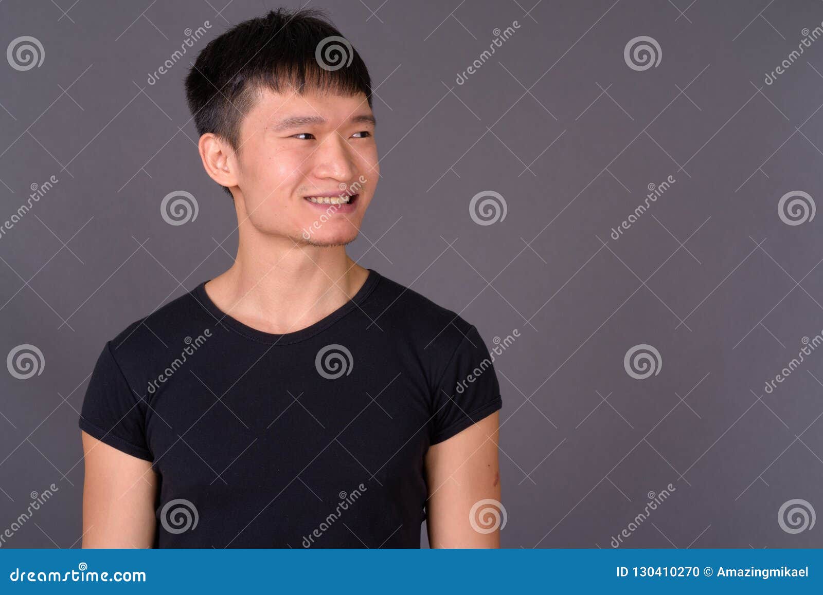 Studio Shot of Young Chinese Man Against Gray Background Stock Photo ...