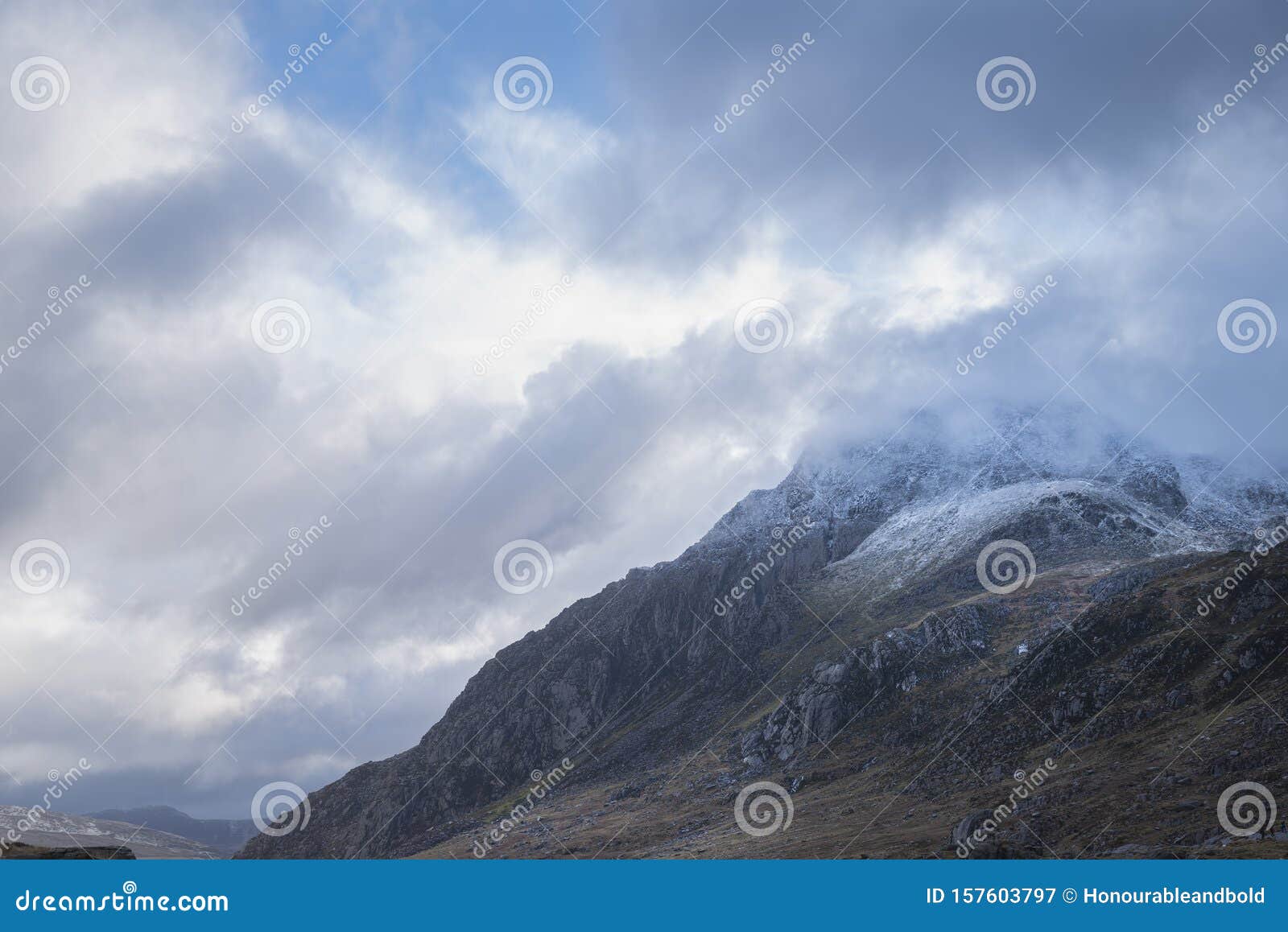 Stunning Moody Dramatic Winter Landscape Image of Snowcapped Tryfan Mountain in Snowdonia with