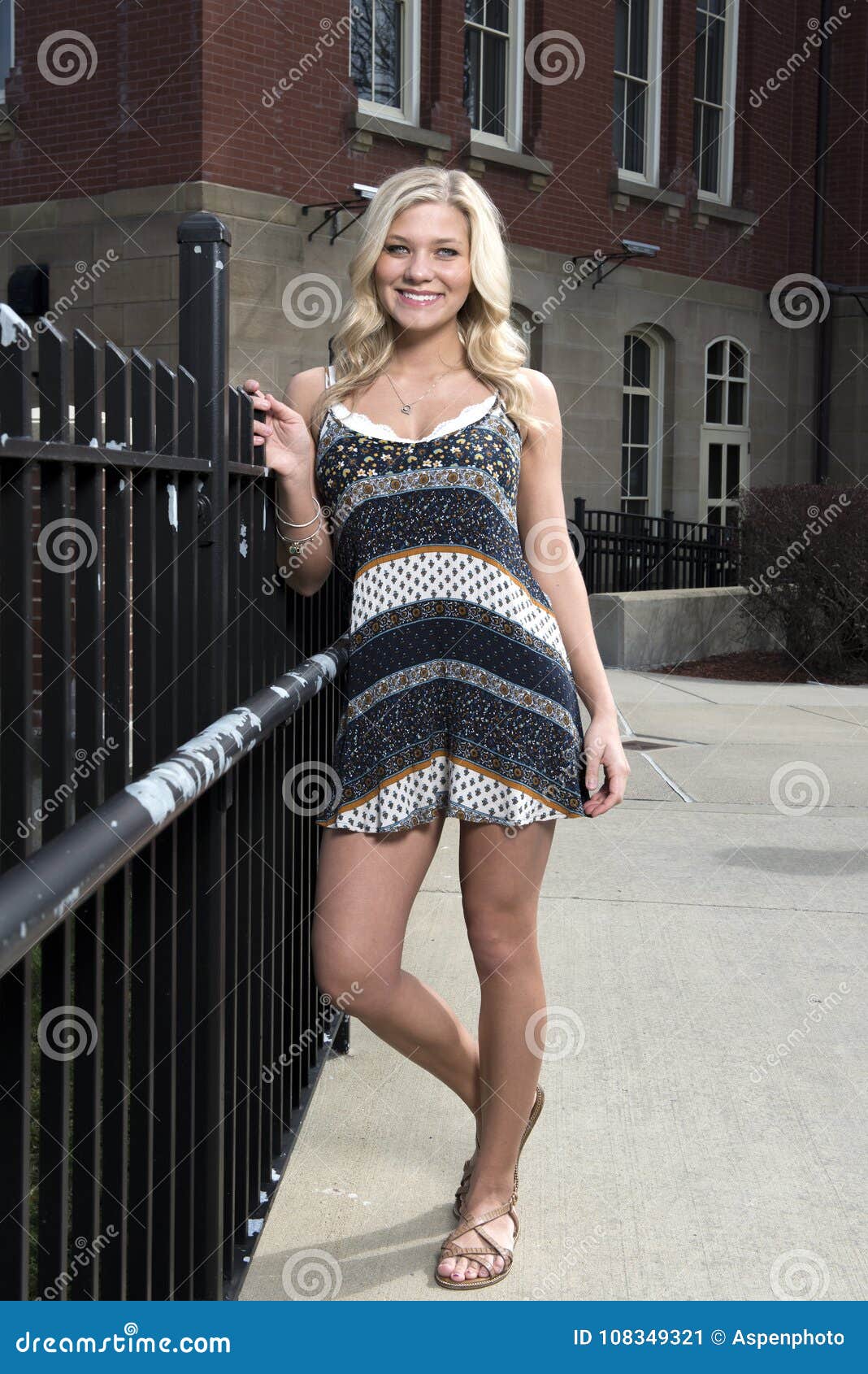 adorable young blonde college student on campus in romper or sundress