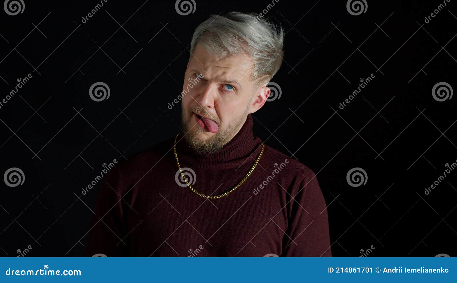 stupid comical stylish man making funny silly face grimace, playing fool, showing tongue, brainless