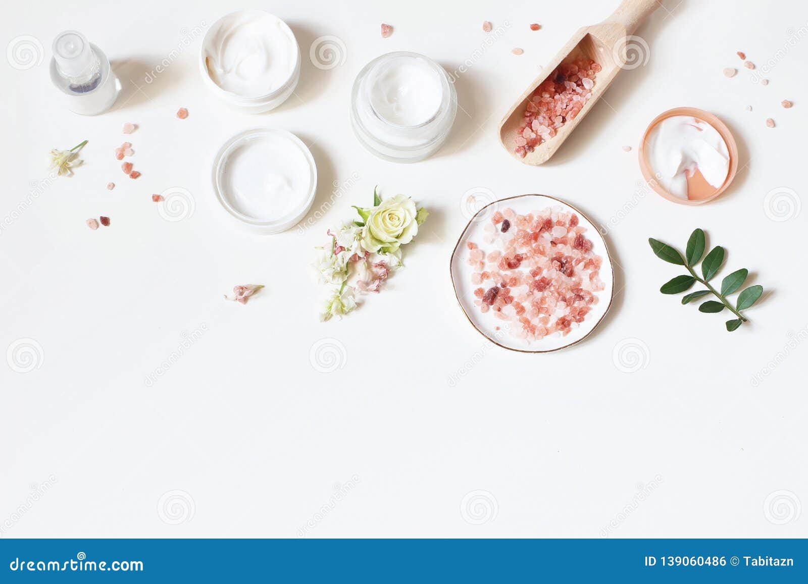 styled beauty frame, web banner. skin cream, tonicum bottle, dry flowers, leaves, rose and himalayan salt. white table