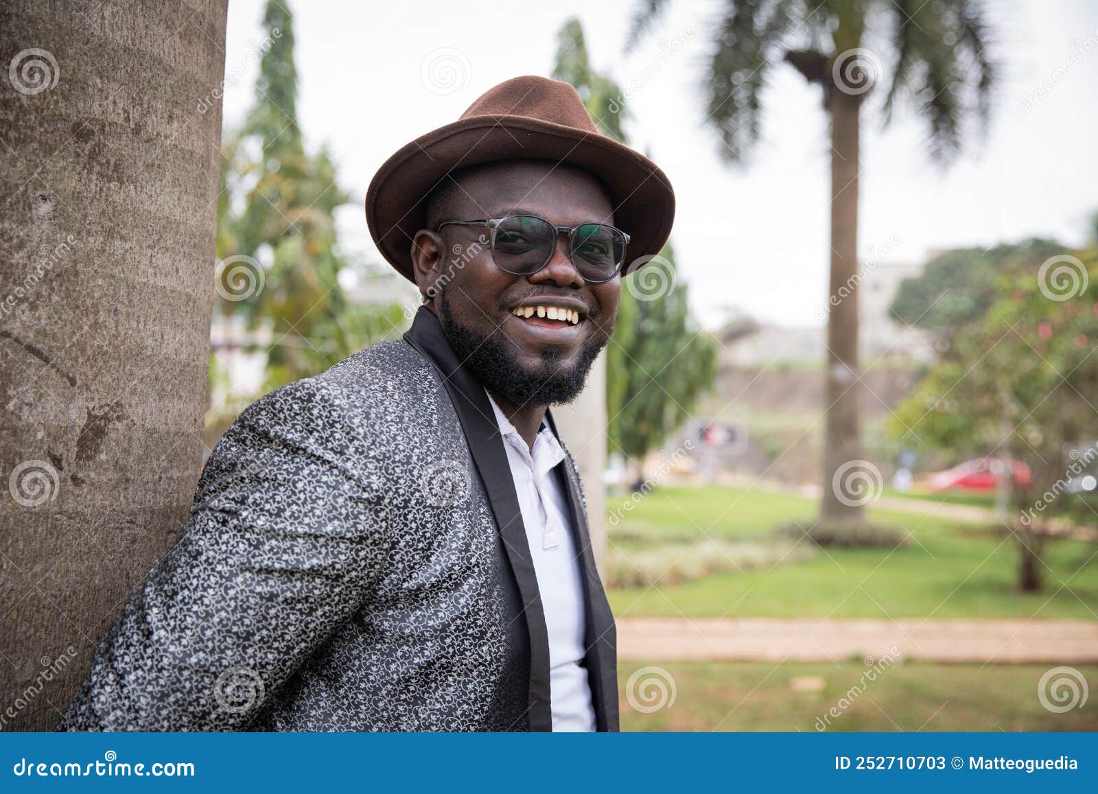 stylish african businessman looks smilingly around in the park. outdoor concept