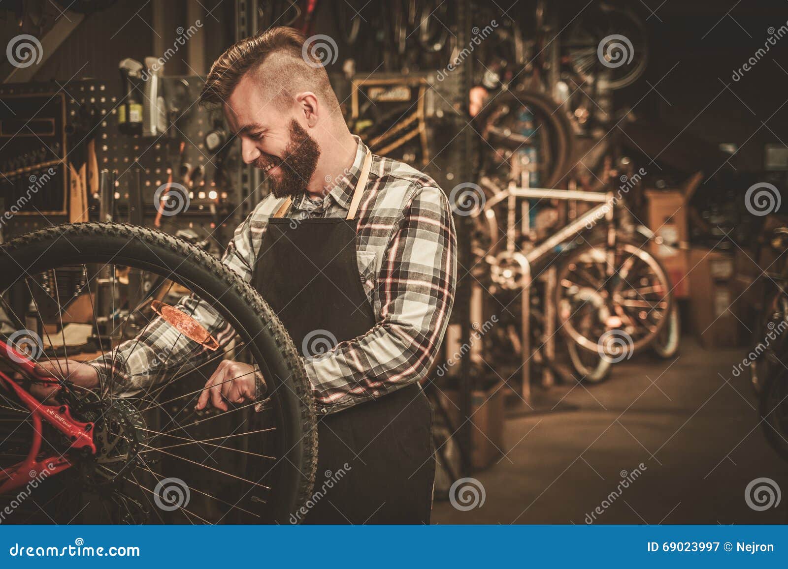 Stylish Bicycle Mechanic Doing His Professional Work in Stock