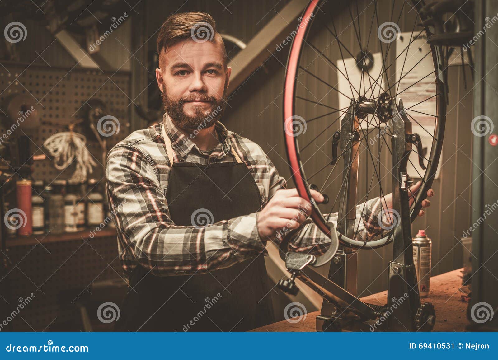 Stylish Bicycle Mechanic Doing His Professional Work in Stock