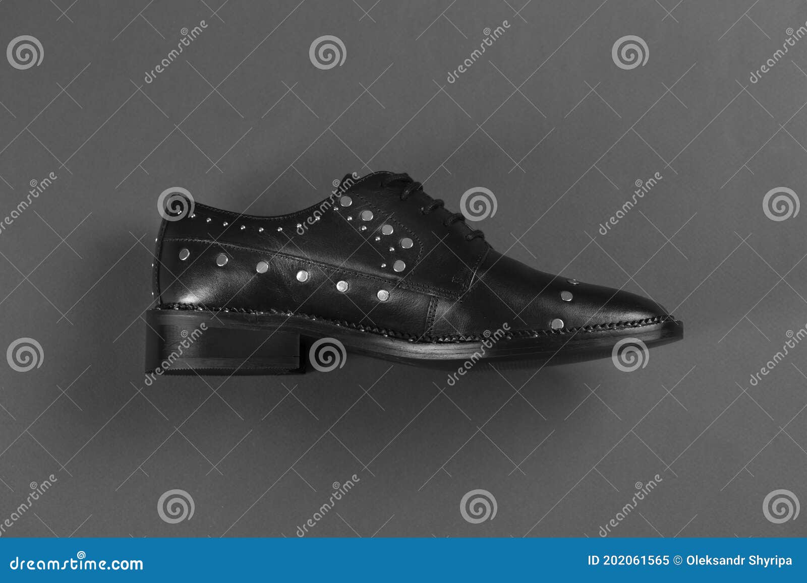 Stylish Black Leather Female Shoes with Rivets on a Gray Background ...