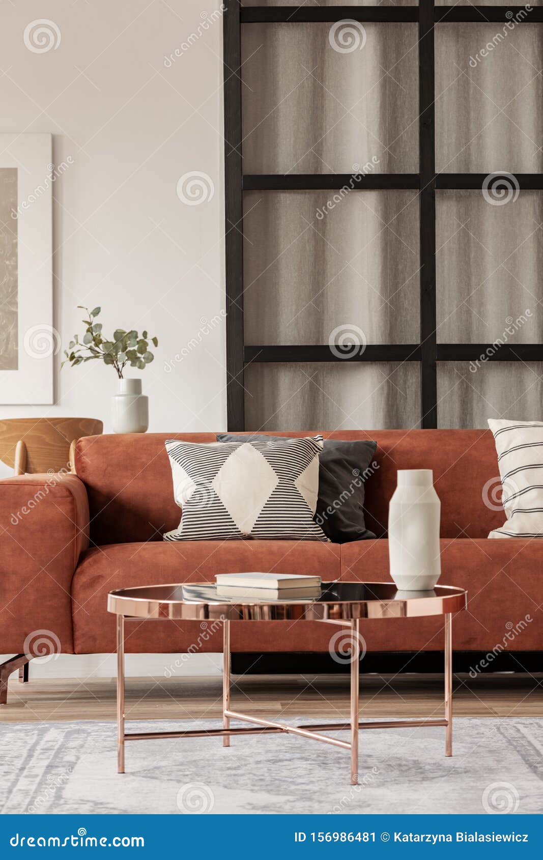 Stylish Brown Corner Sofa with Patterned Pillows in Elegant Living Room Interior with Mullions