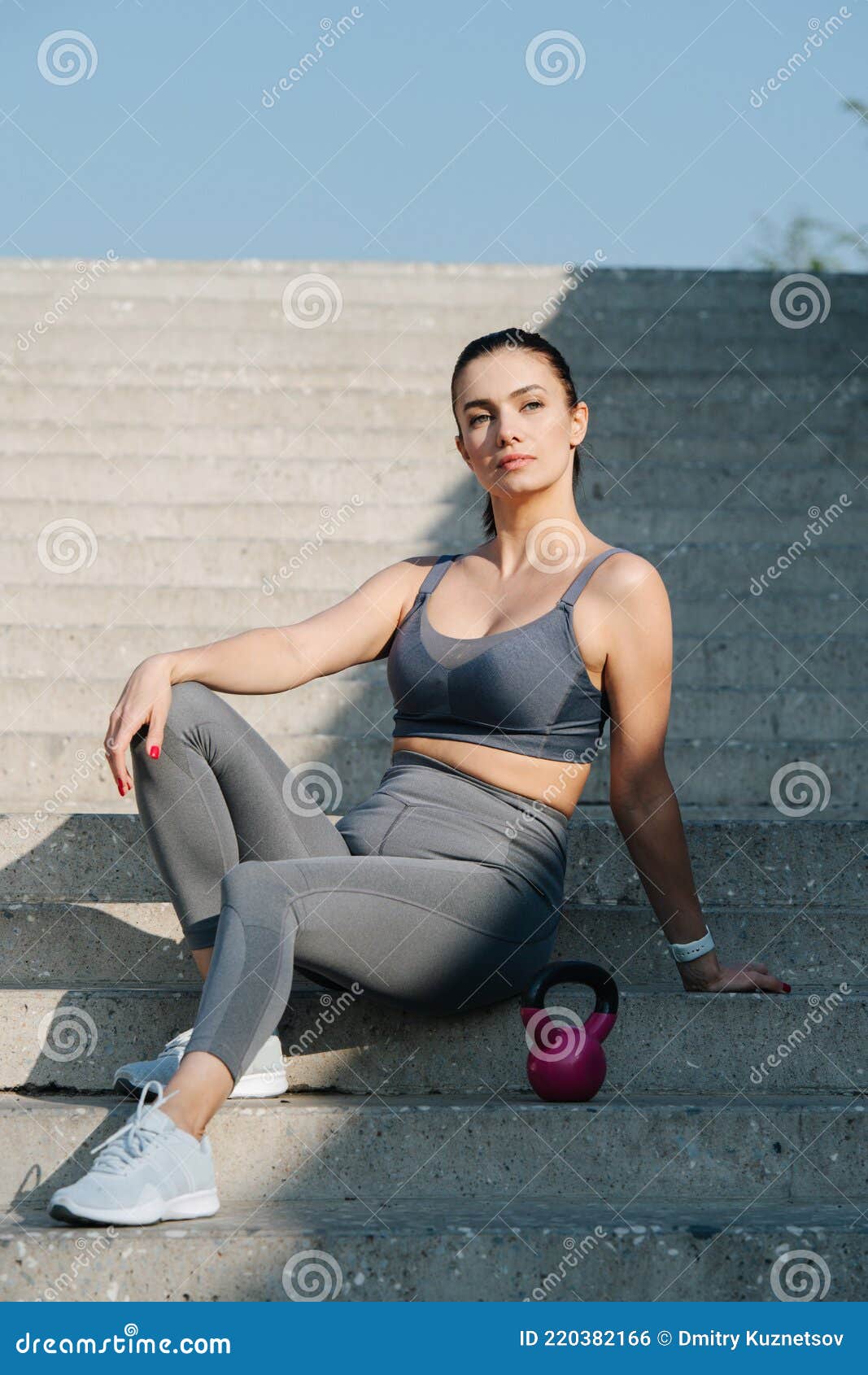 Stylish Brunette Sitting on the Long Stairs Outdoors, Posing with a ...