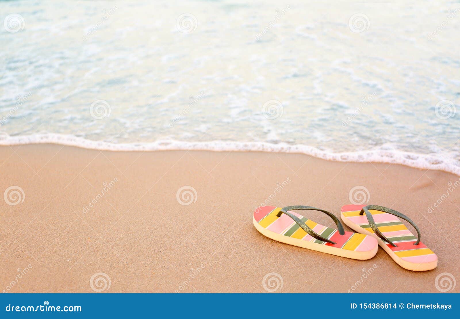 Stylish Flip Flops on Sand Near Sea, Space for Text. Beach Stock Photo ...