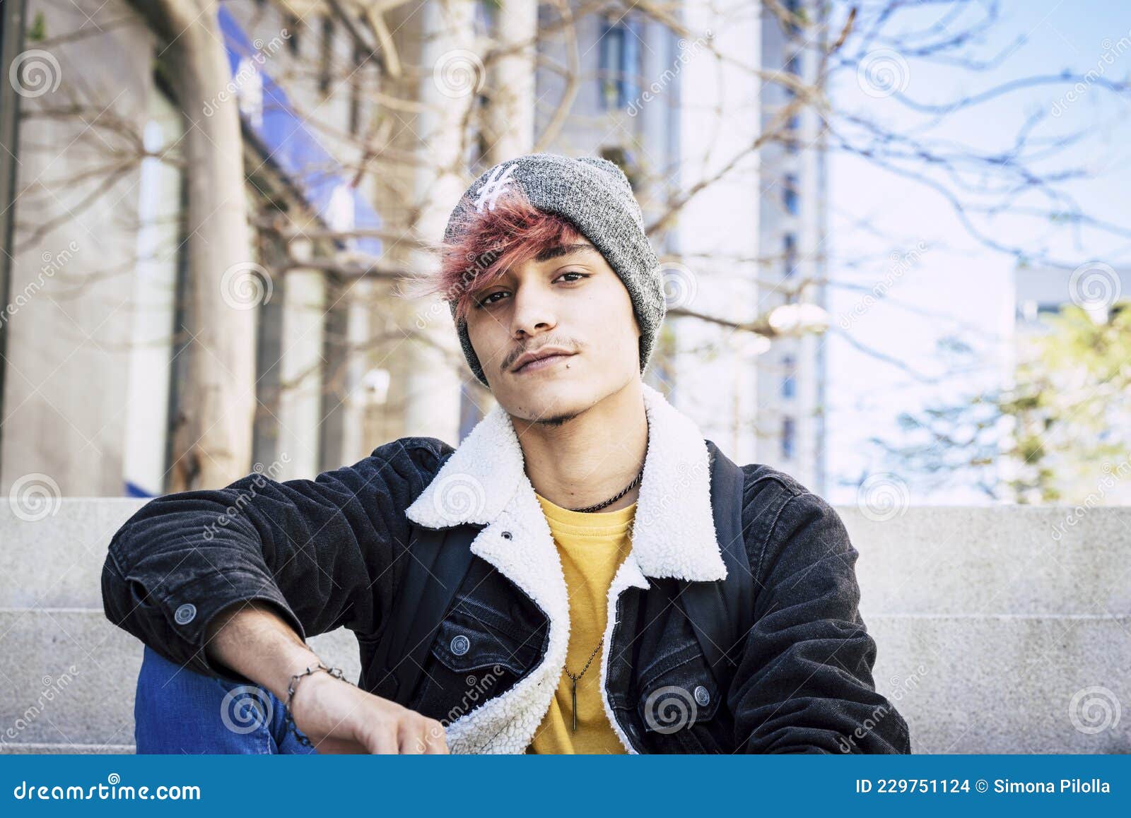 Stylish Handsome Teenage Boy in Knit Hat and Denim Jacket with Burgundy Hair  Color Posing while Sitting on Steps Outdoors in the Stock Photo - Image of  branch, rebel: 229751124
