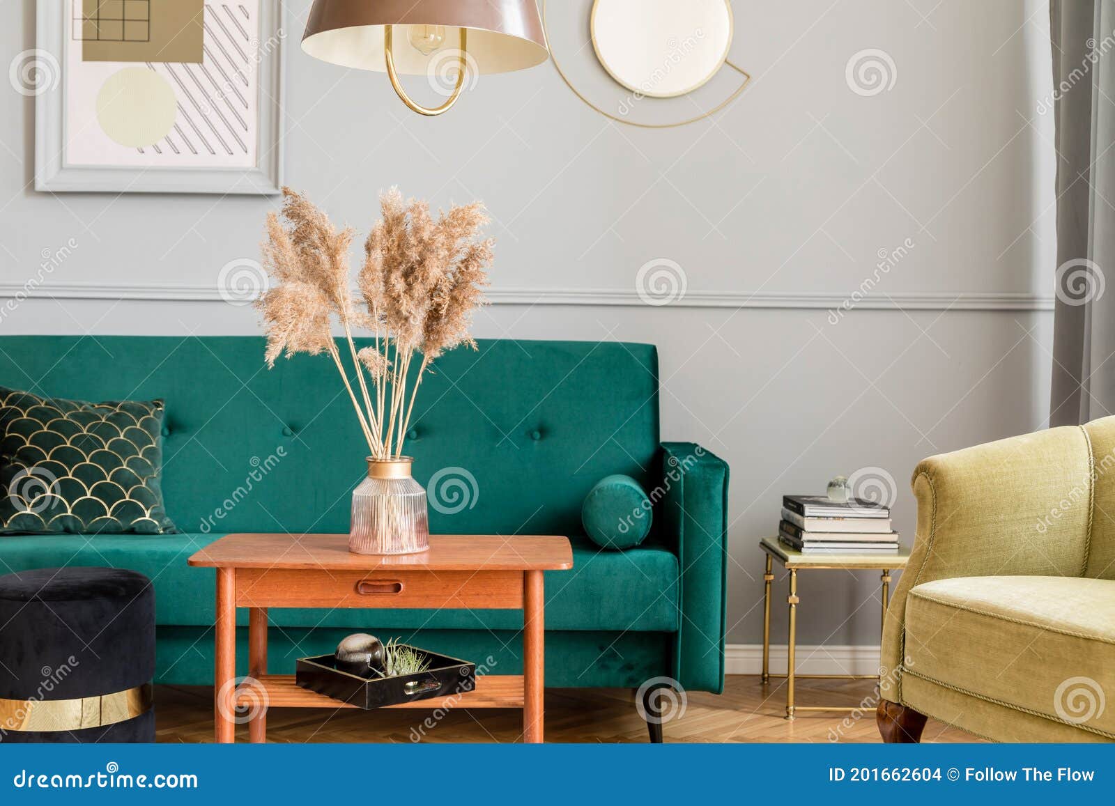 Stylish and luxury living room interior with elegant green velvet armchair, sofa, mock up poster and decoration. Stylish and luxury living room interior with elegant green velvet armchair, sofa, coffee table, marble stands, design lamps, art paintings and chic accessories in home decor