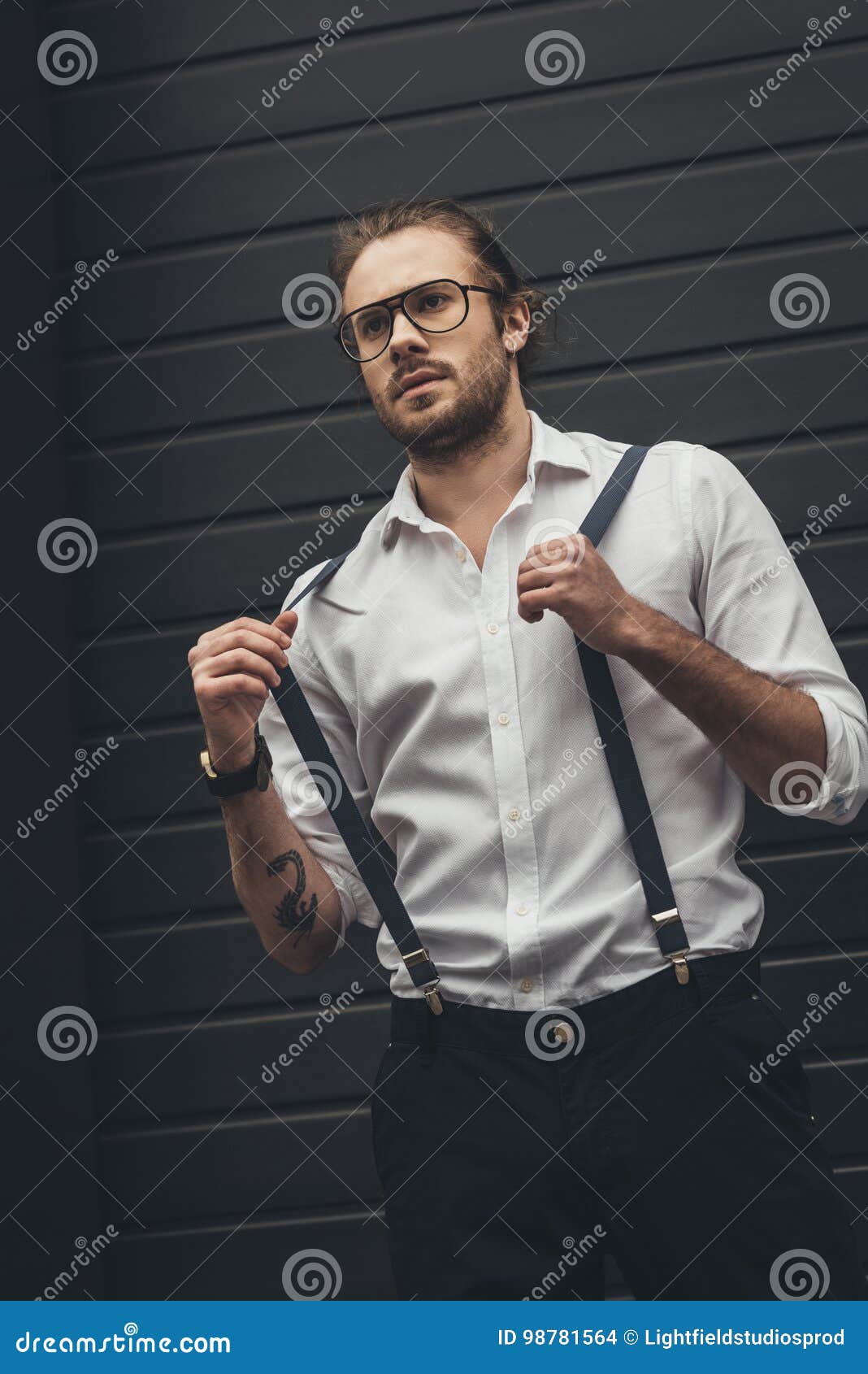 Stylish Man in Spectacles Adjusting Suspenders and Looking Away Stock ...