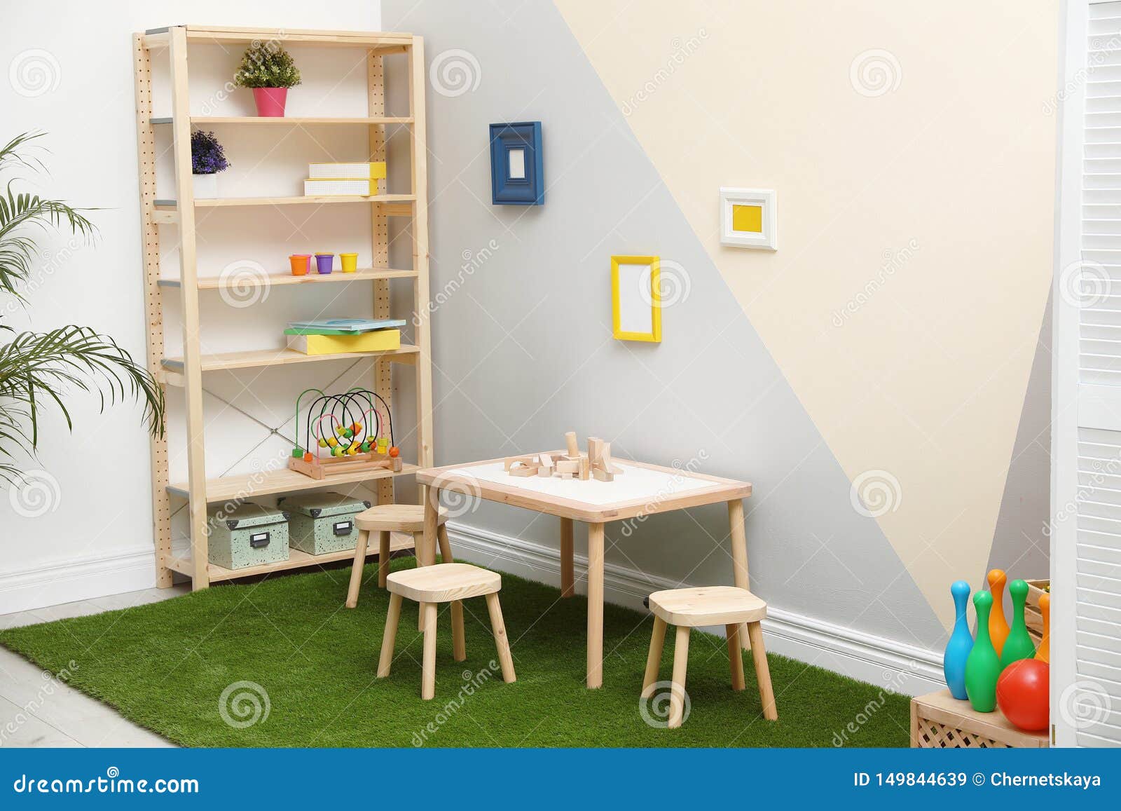 Playroom Interior with Table, Stools and Green Carpet Stock Image