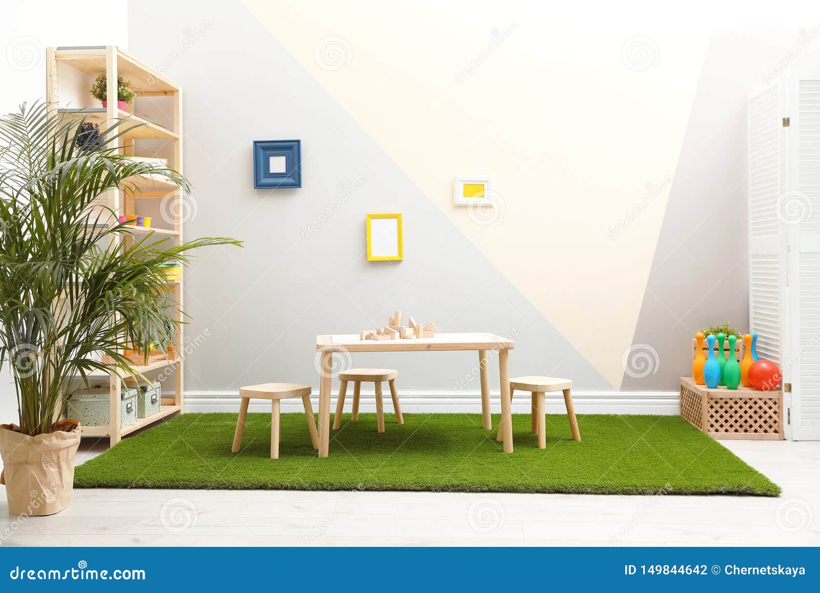 Stylish Playroom Interior with Table, Stools and Green Carpet Stock