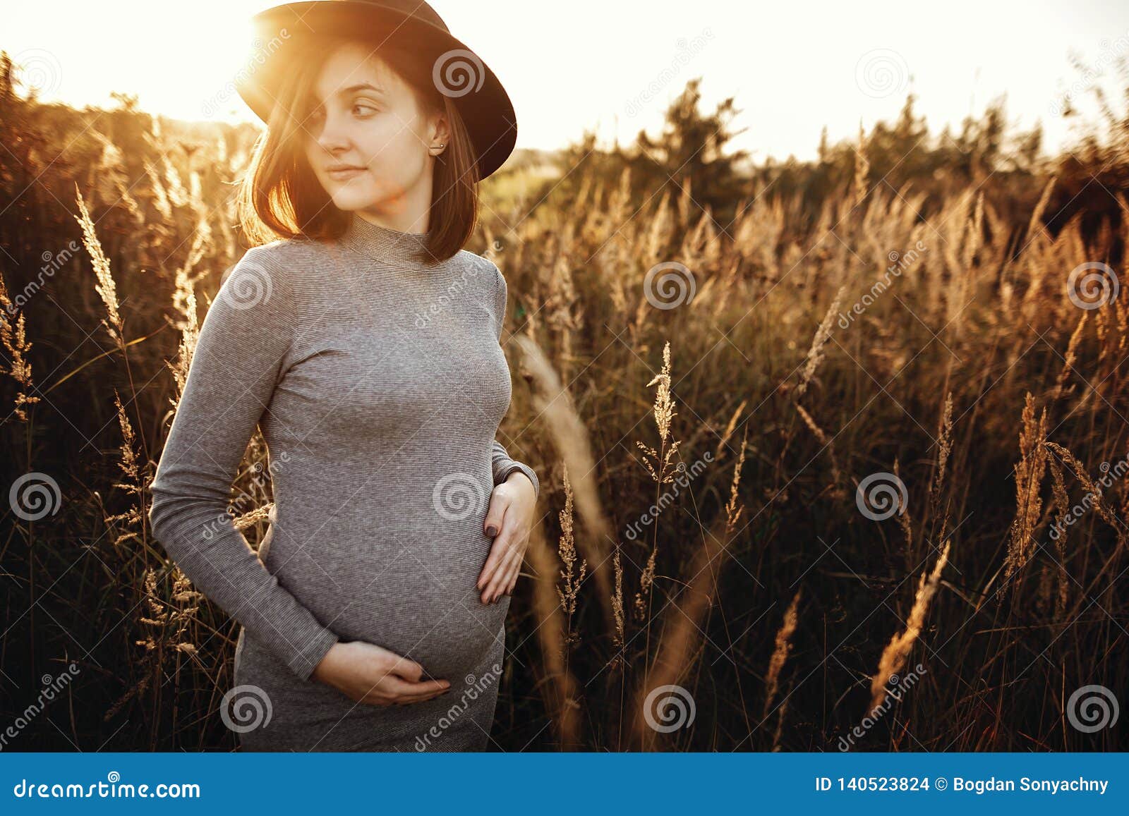 Stylish Pregnant Woman Holding Hands on Belly and Relaxing in Sunny ...