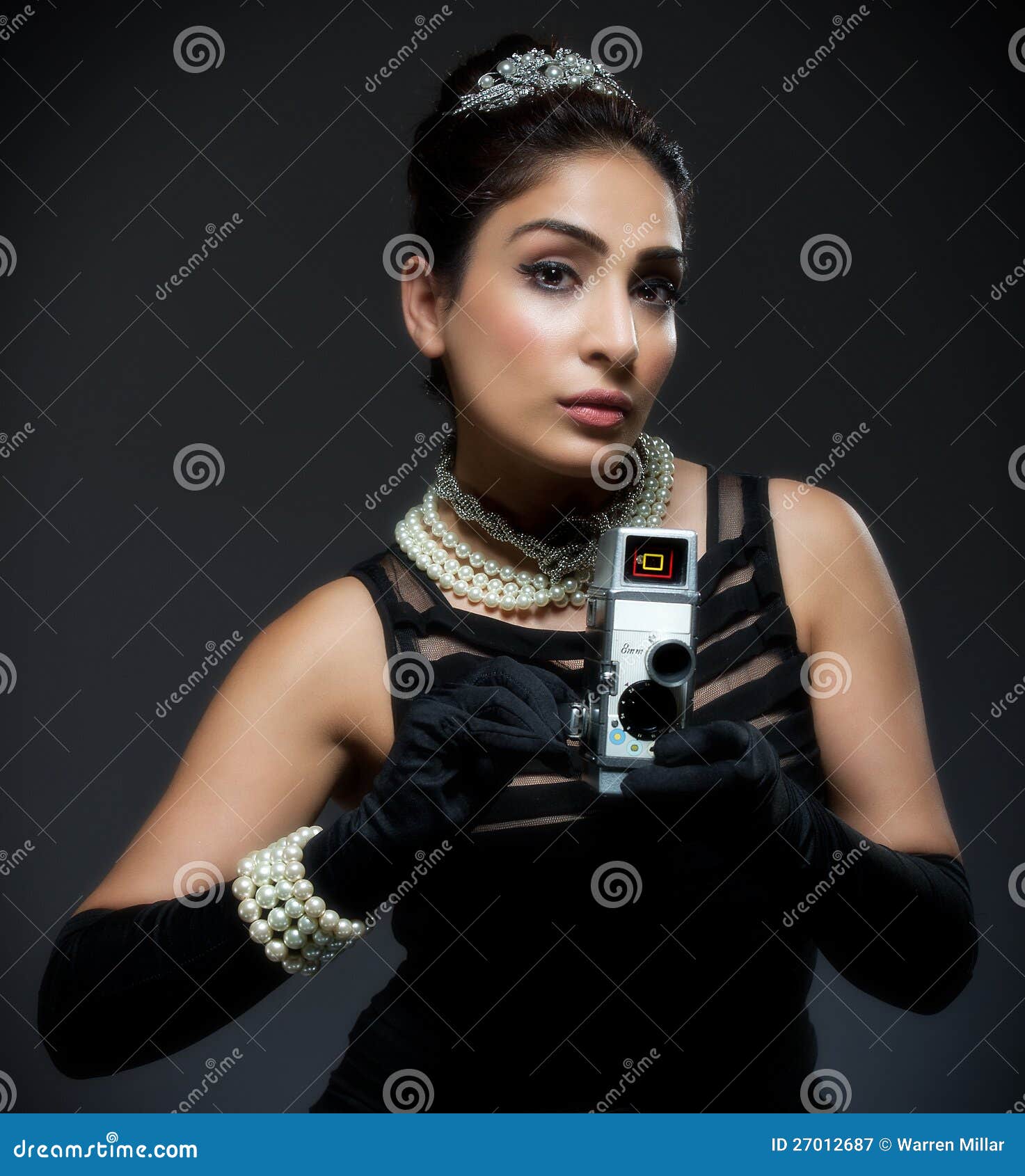 Stylish retro young woman with movie camera. Image showing stylish retro young woman in black dress with movie camera