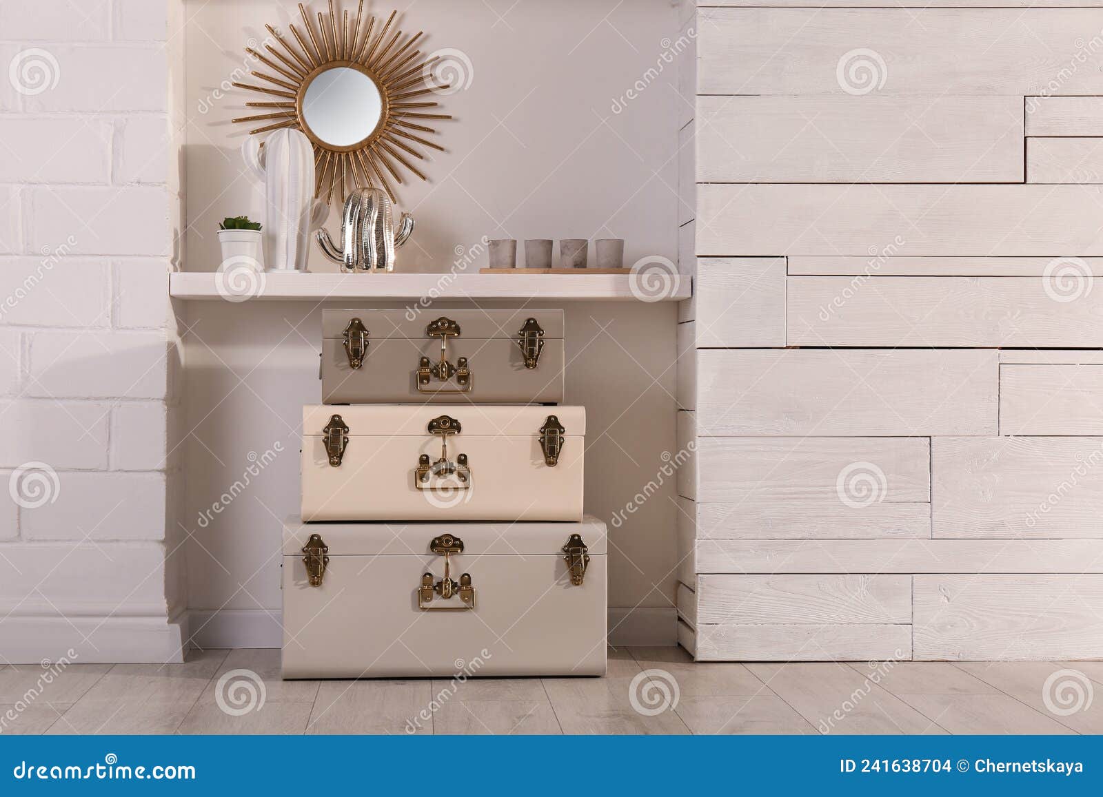 Stylish Storage Trunks and Different Decor Elements Near White Wall