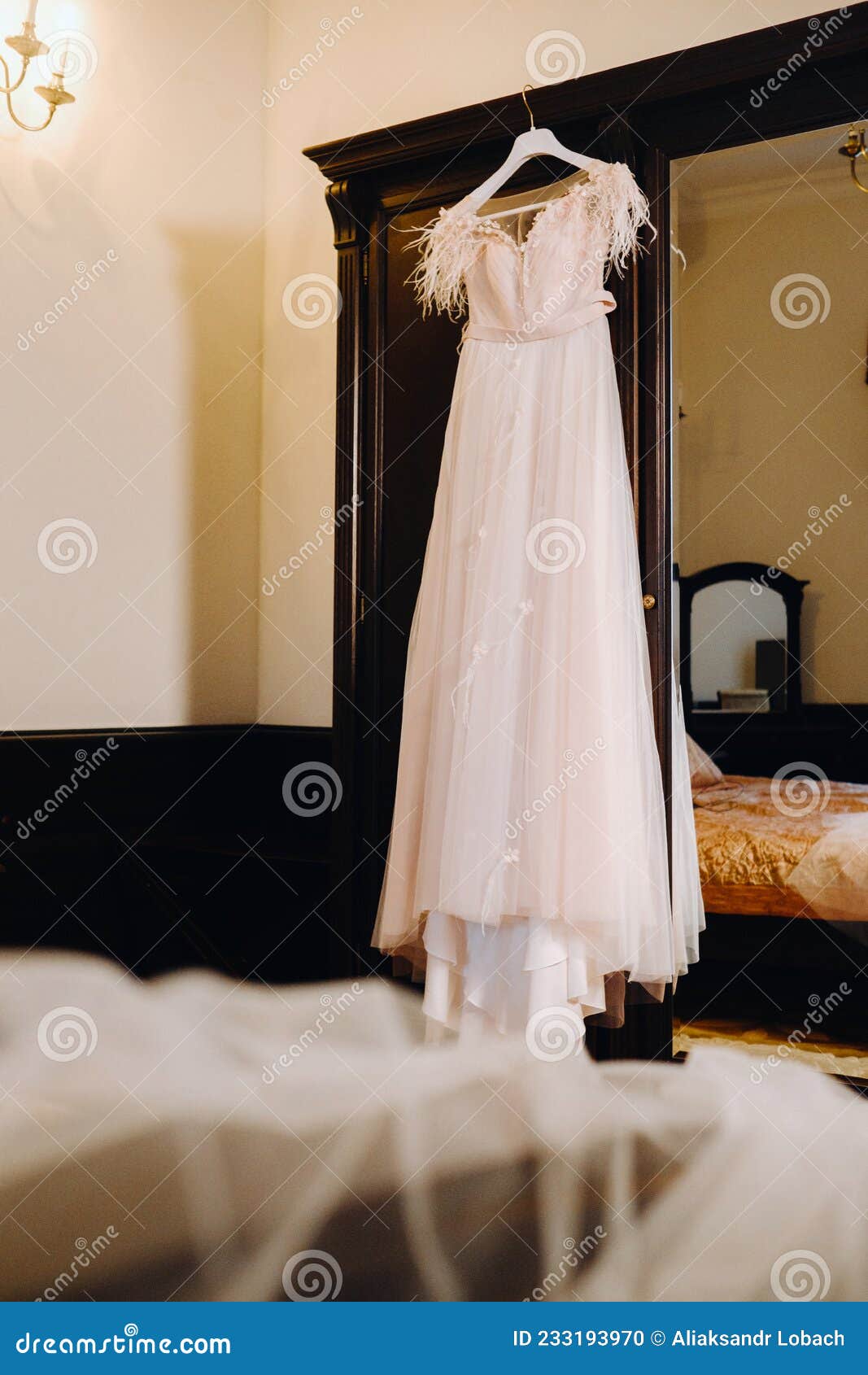 Stylish Wedding Dress Hanging on a Wooden Hanger in the Interior Stock ...