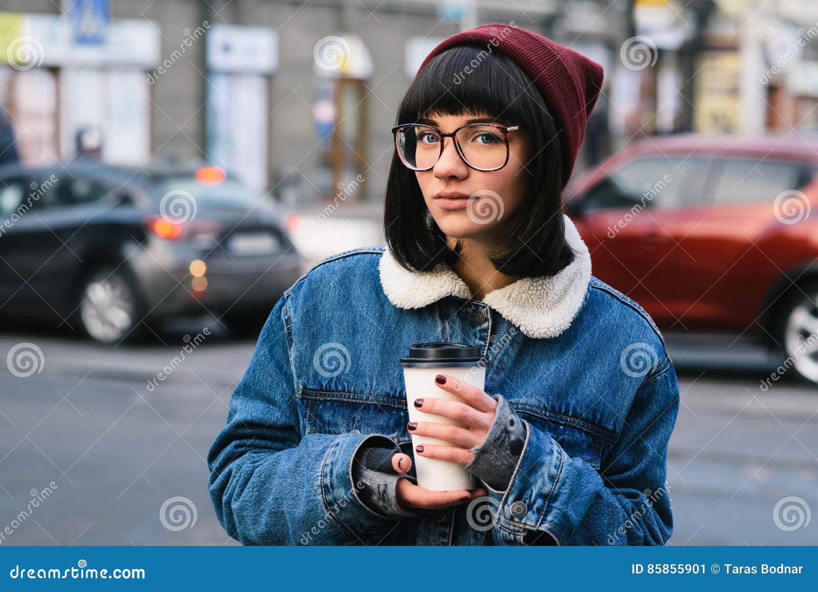 Stylish Young Hipster Girl Walks in the City and Drinking Coffee