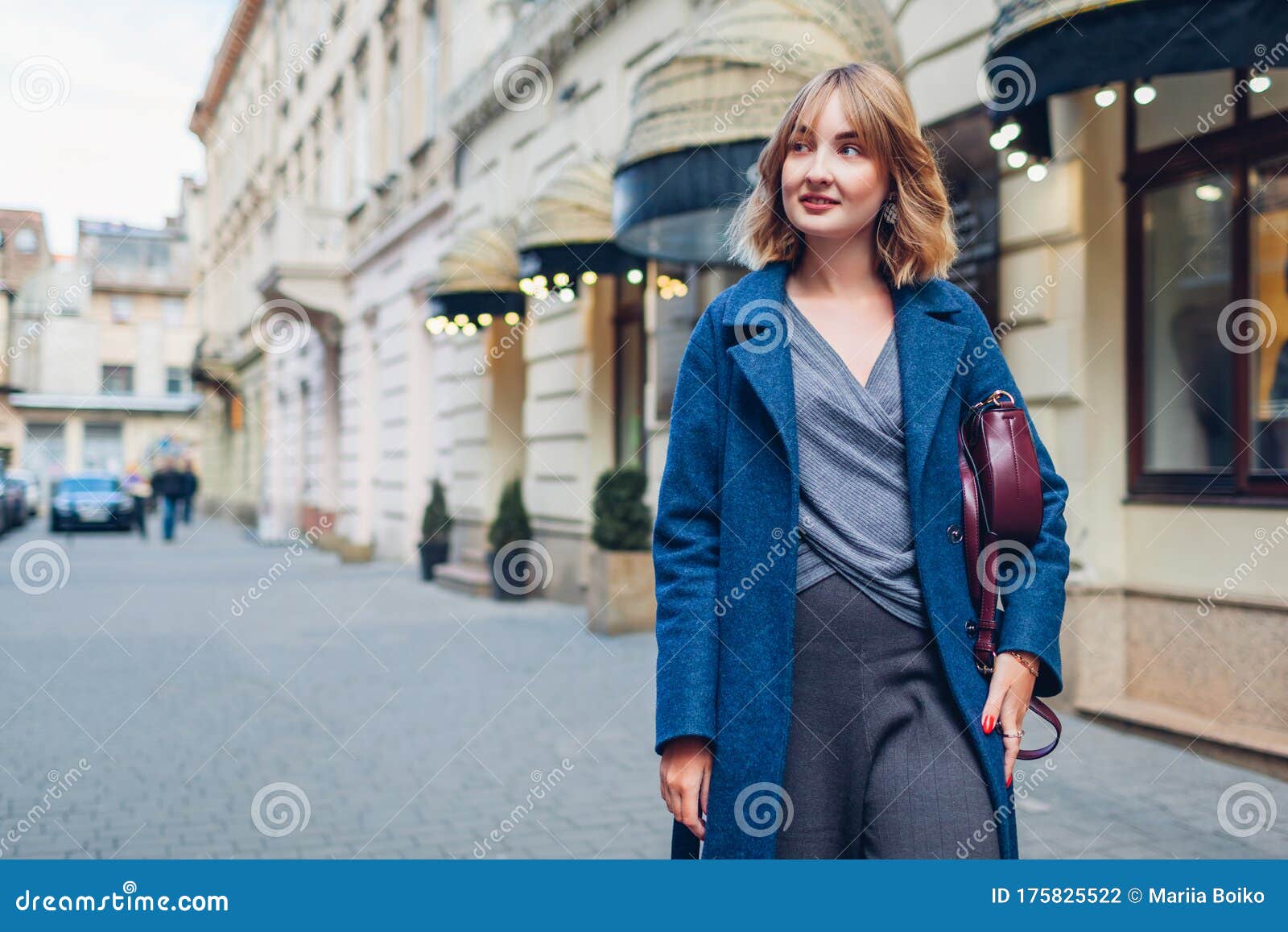Stylish Young Woman Wearing Trendy Outfit Blue Coat Walking with Purse Spring Fashion Female Accessories Stock Photo - of earrings, lvov: 175825522