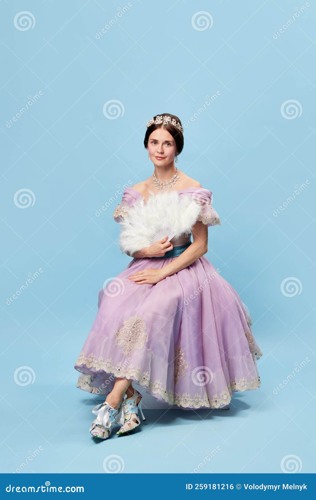 stylishness. beautiful charming girl in lilac color medieval dress as young queen or princess on blue background. eras