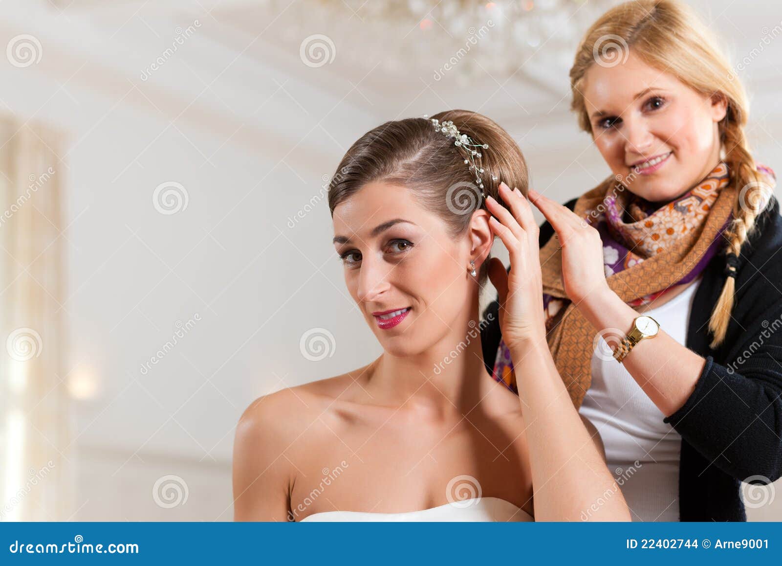 stylist pinning up a bride's hairstyle
