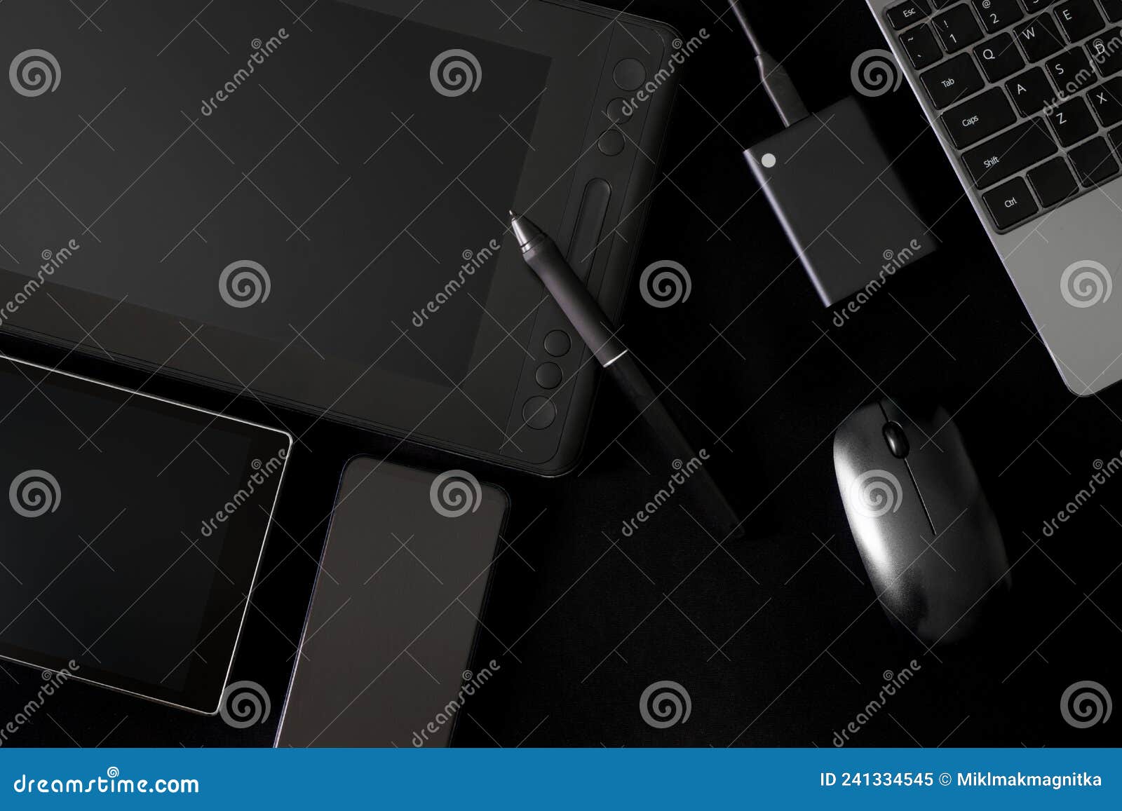 Stylus and Graphics Tablet with Screen on a Black Background Next To Laptop, Computer Mouse