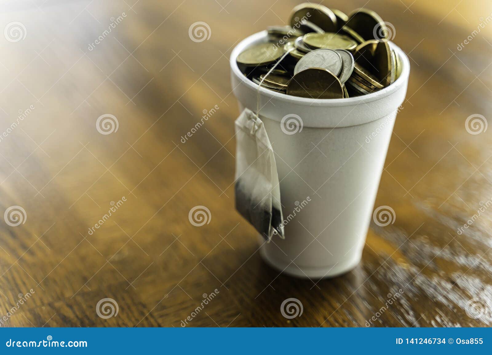 Styrofoam Cup Filled with Coins and Tea Bag Hanging Outside Stock Photo