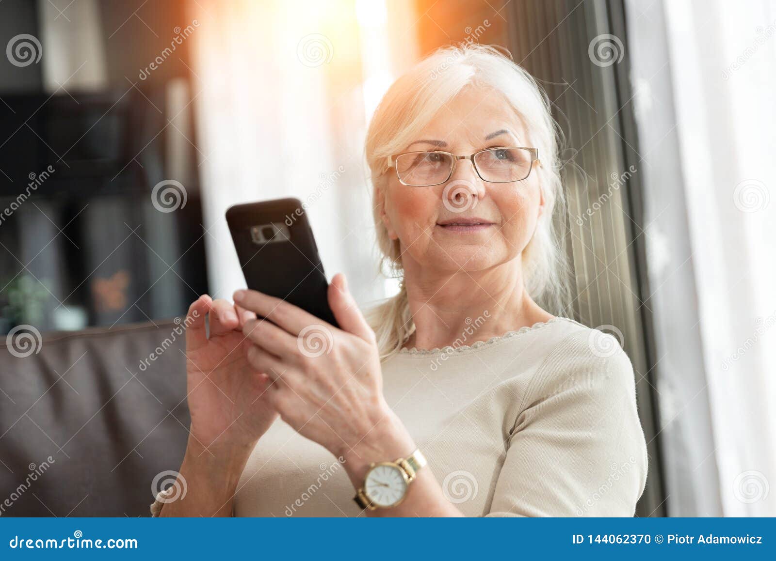 Stående av den eleganta höga kvinnan med den smarta telefonen Livsstilfoto av pensionkvinnan
