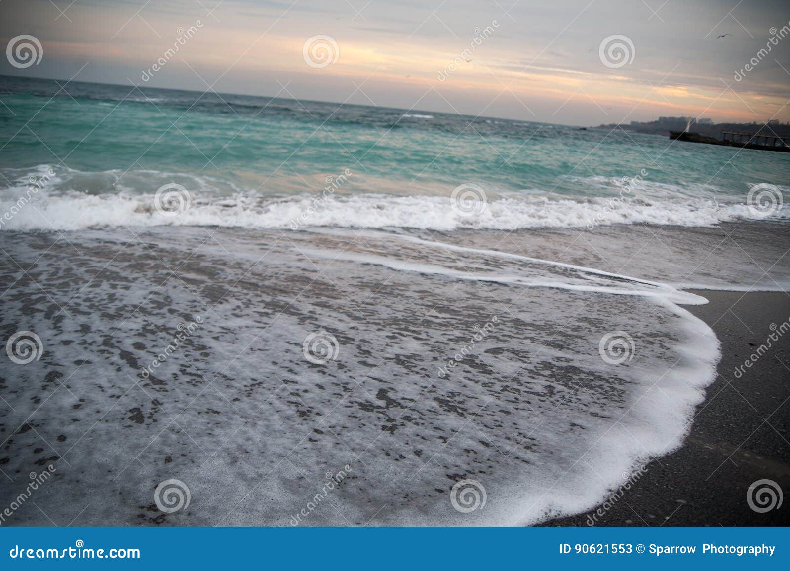 Stürmisches Meer des Türkises mit dem Schäumen bewegt bei dem Sonnenuntergang wellenartig. Türkiswasser des Meeres in einem Sturm mit schäumenden Wellen, Schuss bei dem Sonnenuntergang