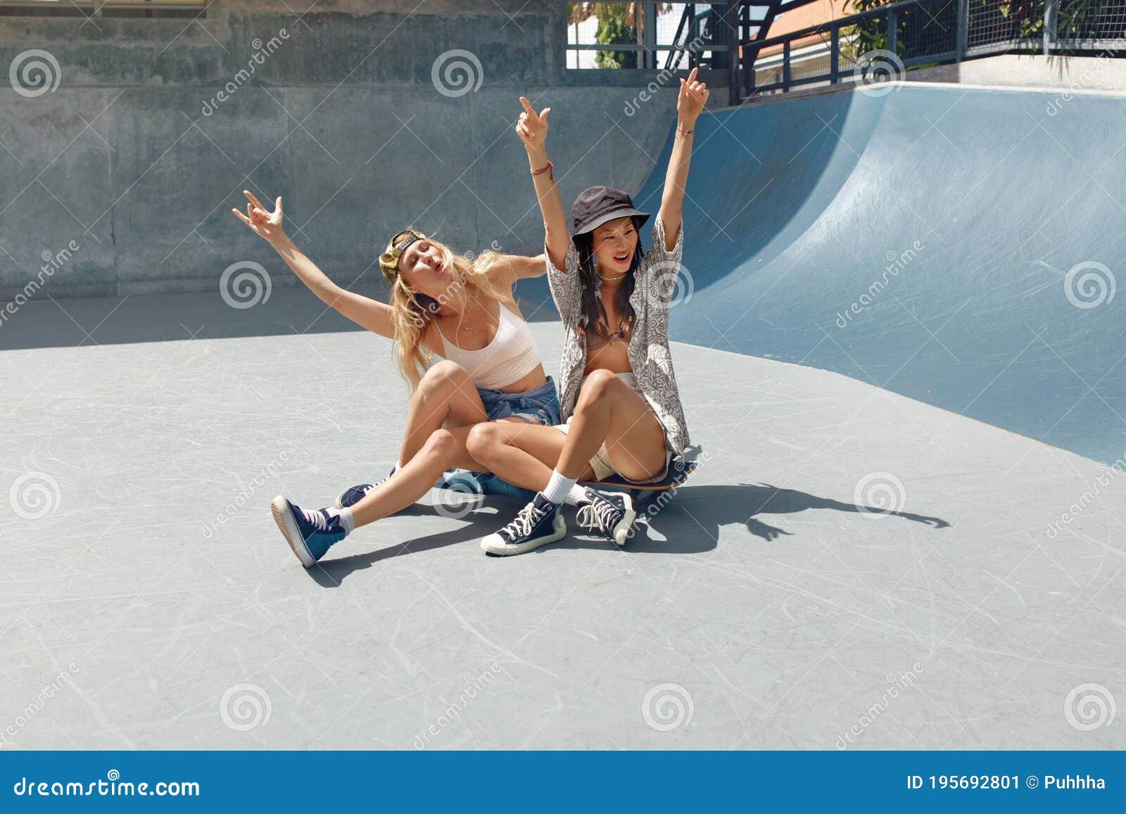 subculture. skater girls sitting on skateboards and having fun at skatepark.