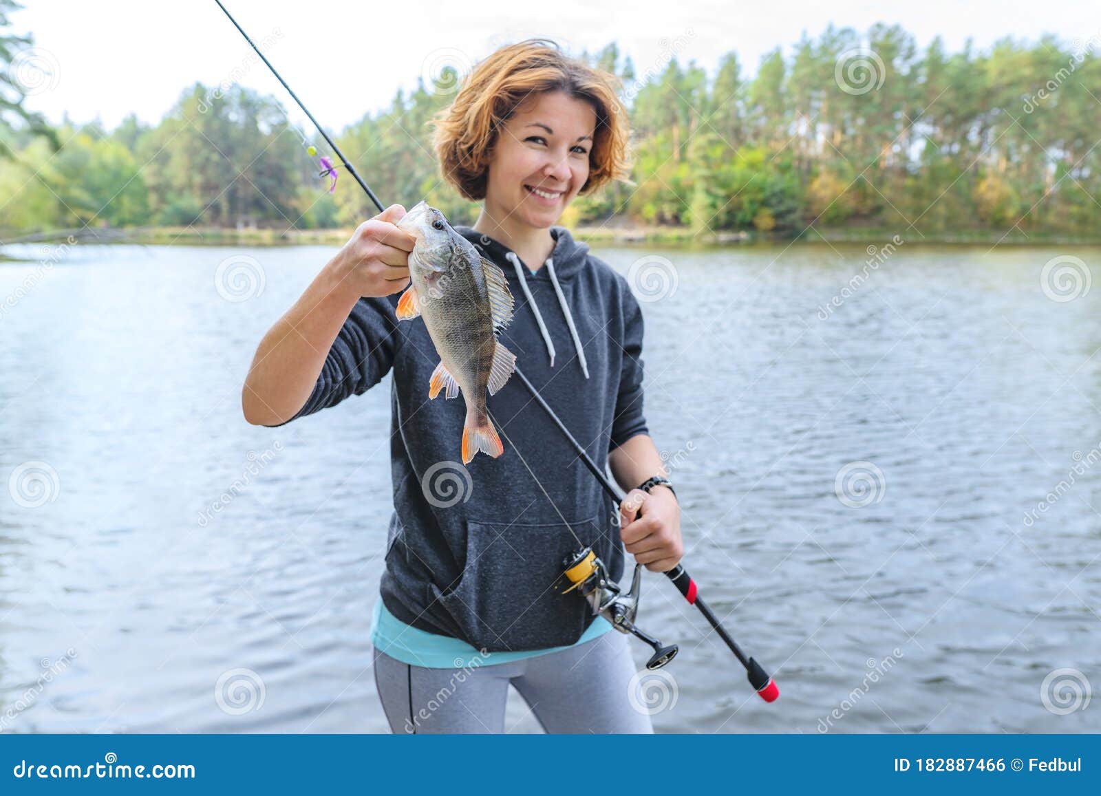 Success Perch Fishing. Lady Fisherwoman with Fish at Lake Stock