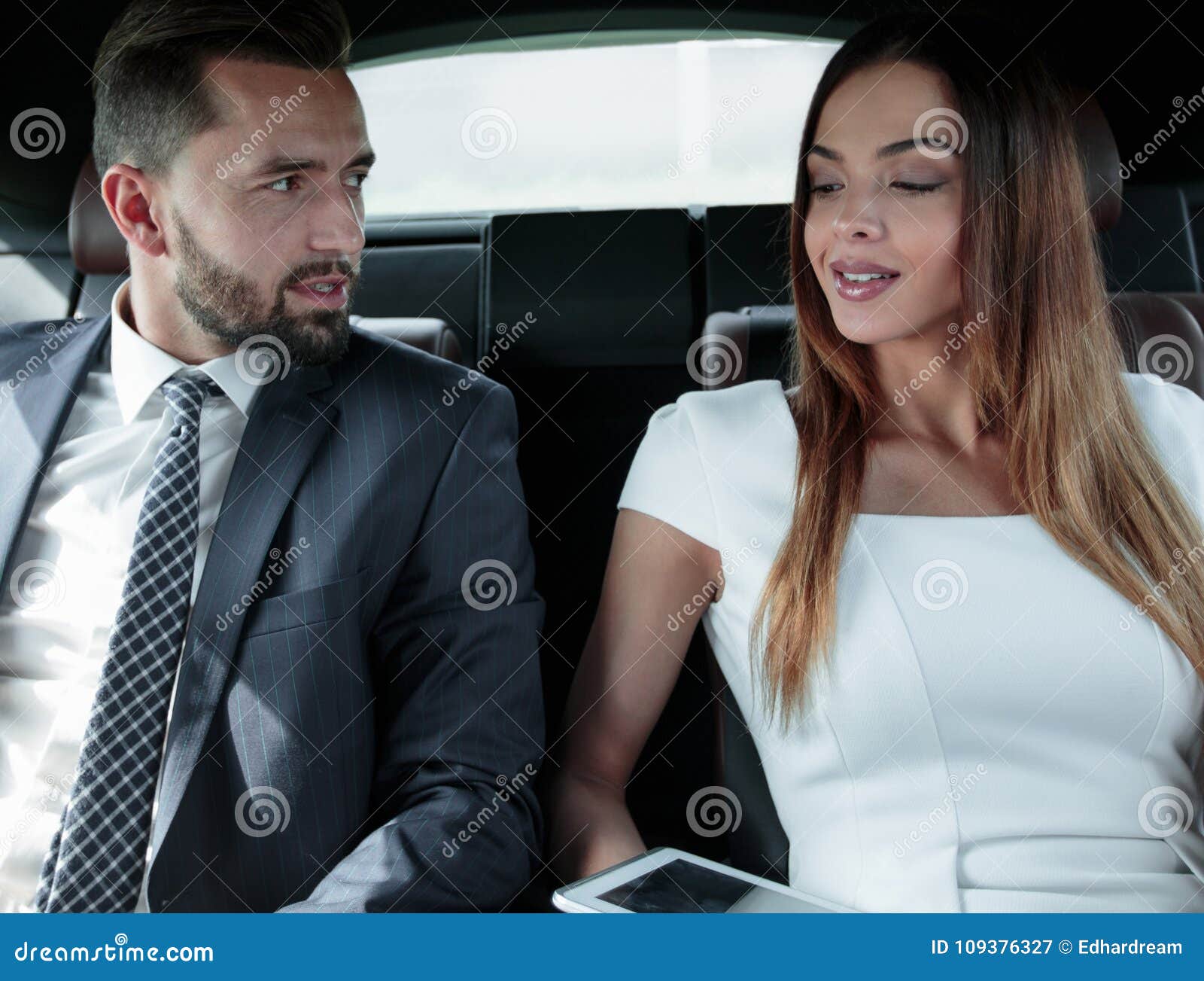 Successful People Working Together In Back Seat Of Car