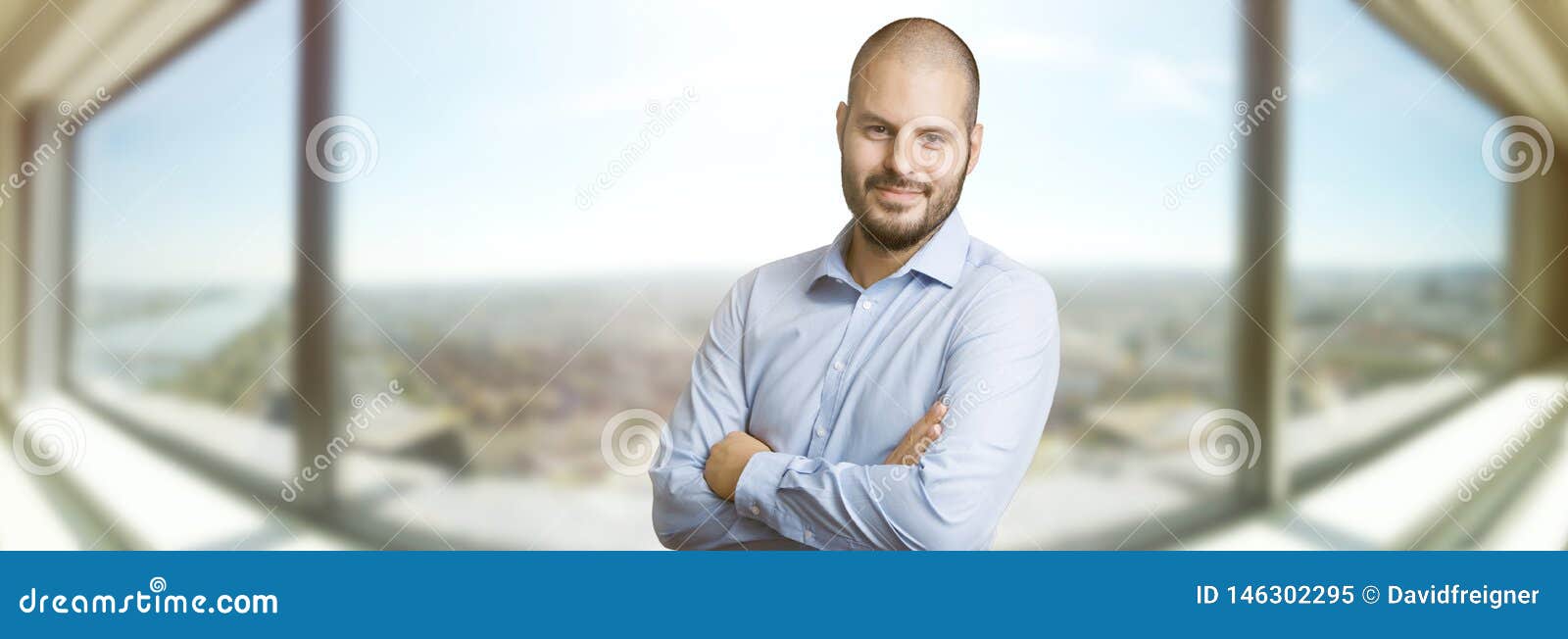 successful smiling man standin in front of the window of a skyscrapper. real estate, business and success concept