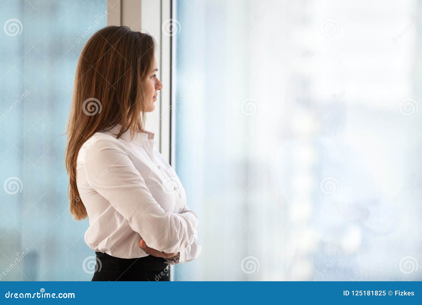 successful thoughtful woman business leader looking out of big w